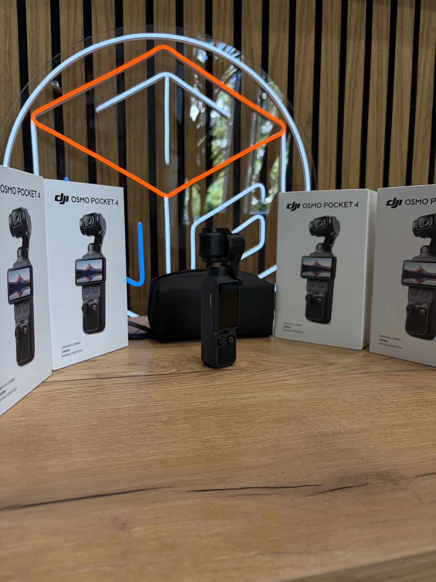 DJI Osmo Pocket 4 рядом с коробками комплекта Creator Combo