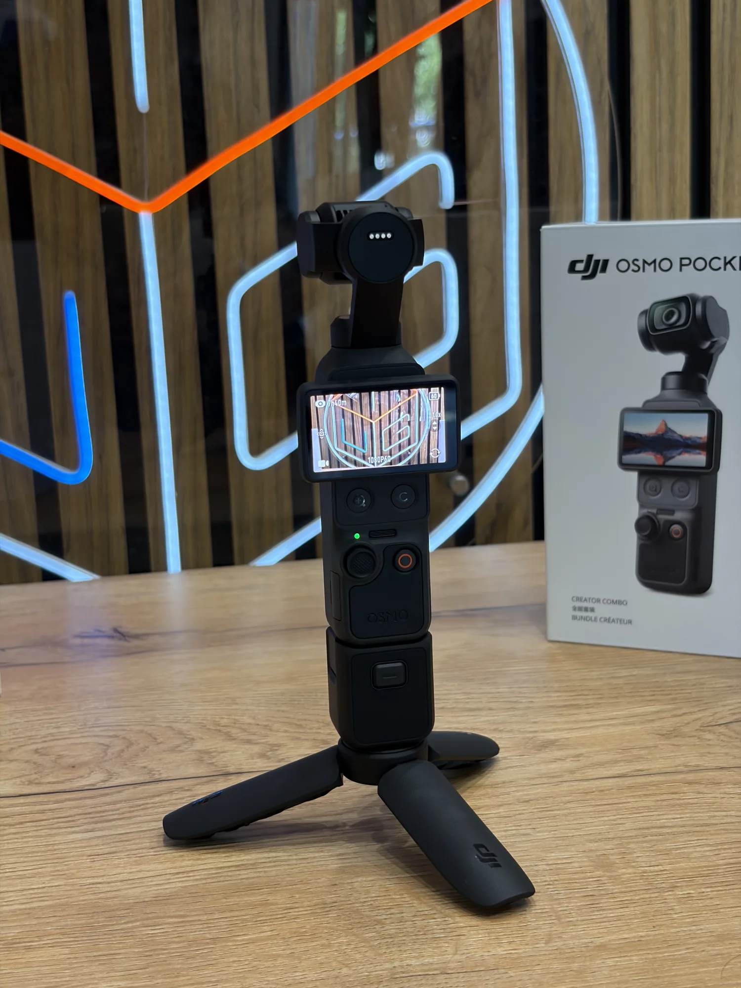 DJI Osmo Pocket 4 на штативе рядом с упаковкой
